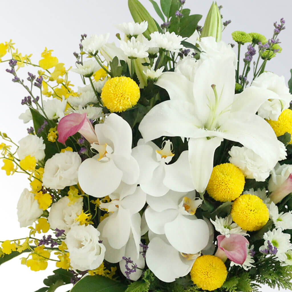真っ白なユリに色花を添えた豪華なアレンジメント